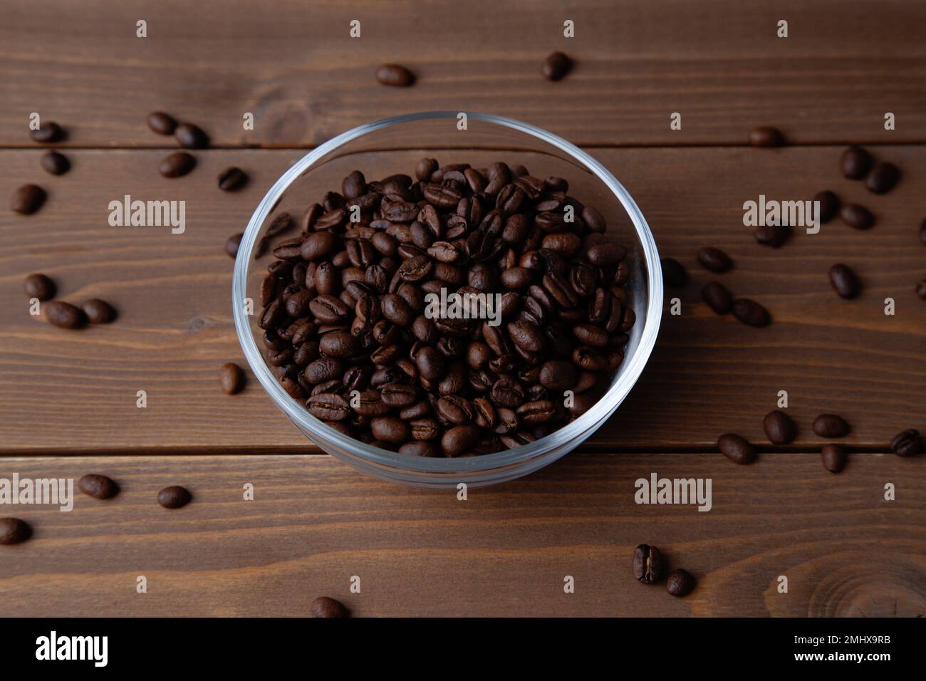 Geröstete Kaffeebohnen in einer Glasschüssel auf dem Tisch Stockfoto