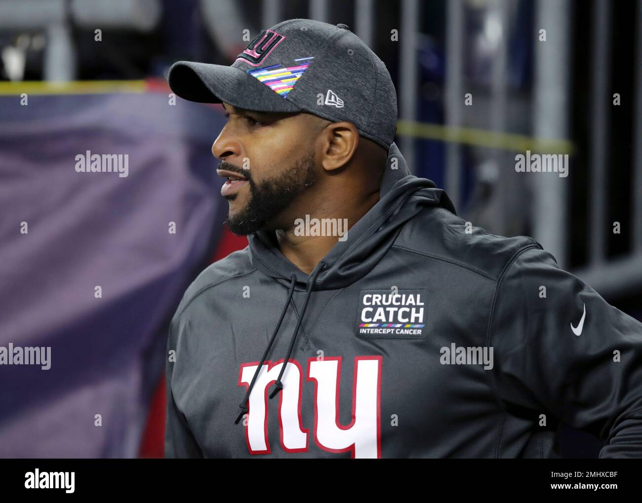 New York Giants assistant offensive line coach Ben Wilkerson wears a patch in support of the Crucial Catch initiative in the fight against cancer while watching his team warm up before an NFL football game against the New England Patriots, Thursday, Oct. 10, 2019, in Foxborough, Mass. (AP Photo/Charles Krupa) Stockfoto