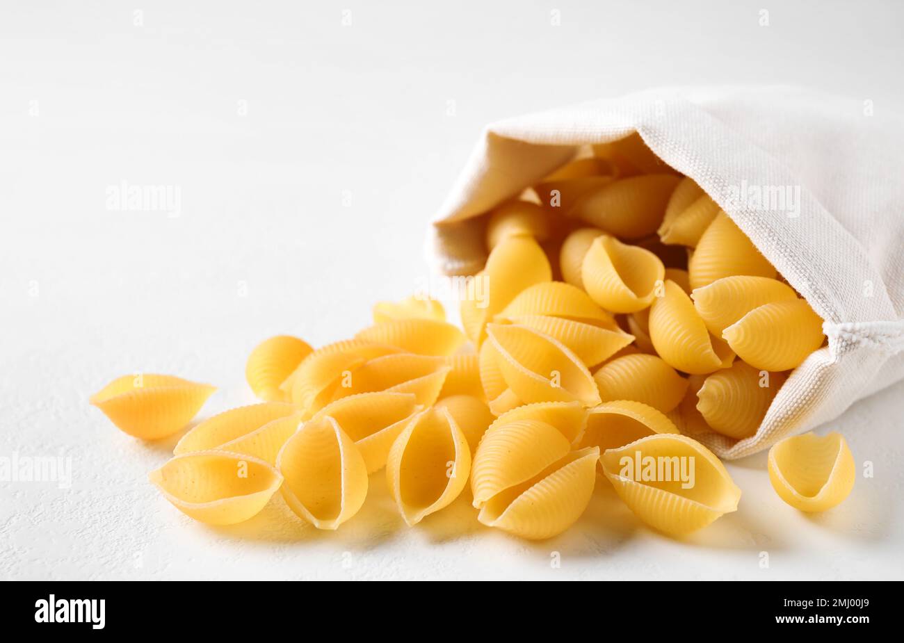 Ungekochte Conchiglie Pasta auf weißem Tisch, Nahaufnahme Stockfoto