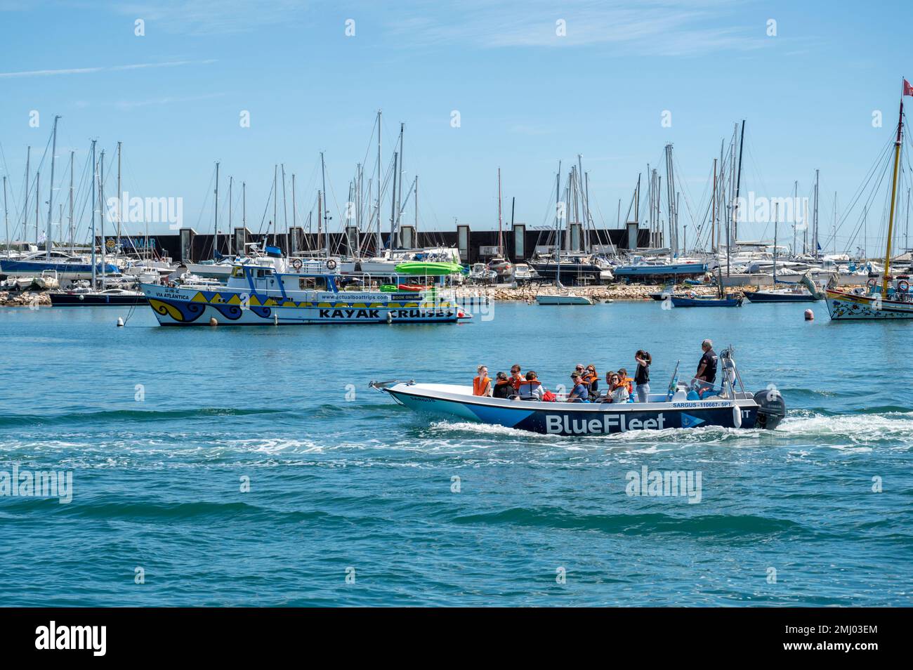 Blaue Touristenboote, die Touristen auf Bootsausflügen in Lagos Portugal transportieren Stockfoto