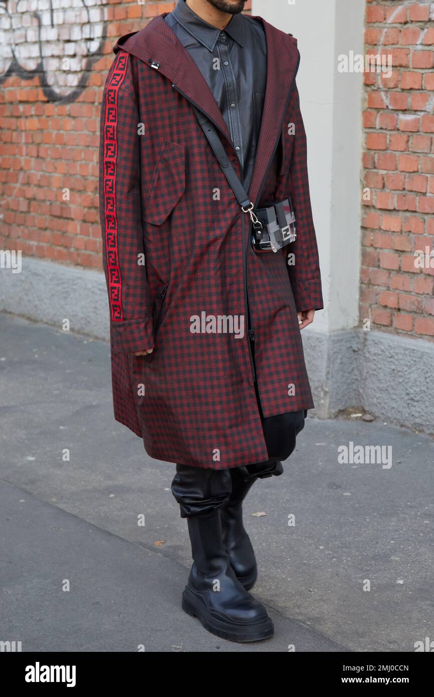 MAILAND, ITALIEN - 14. JANUAR 2023: Mann mit schwarz-rot kariertem Mantel und grauem Hemd vor der Fendi-Modenschau, Mailand Fashion Week Street Style Stockfoto