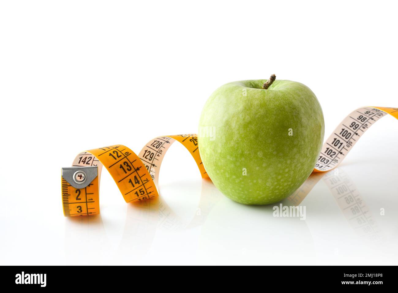Apfel und Maßband reflektiert auf weißem Boden und weißem isoliertem Hintergrund. Gesunder Lebensstil. Vorderansicht. Stockfoto
