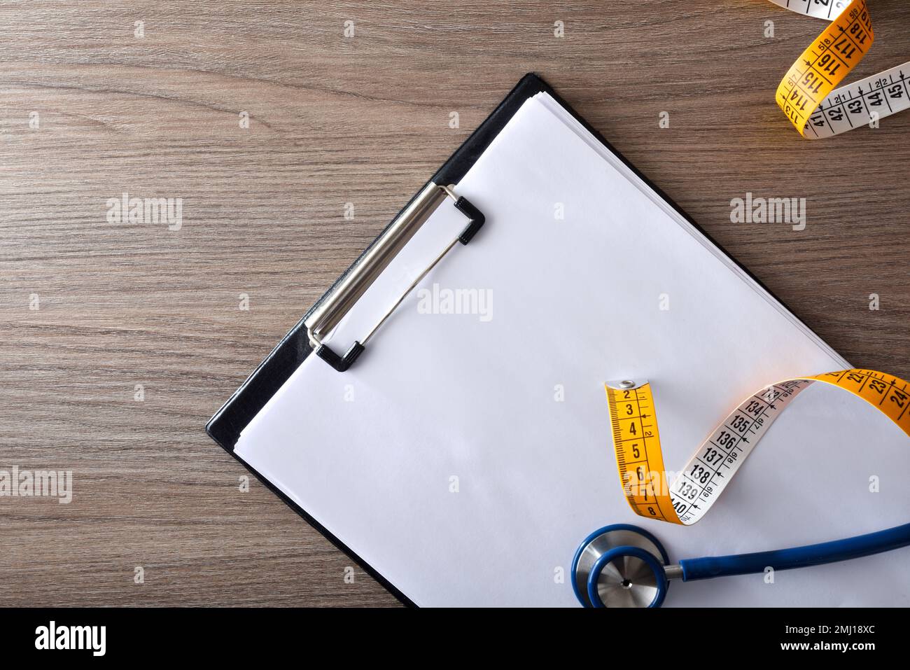 Ordner mit Bögen, Stethoskop und Maßband auf Holztisch für Health Check. Draufsicht. Stockfoto