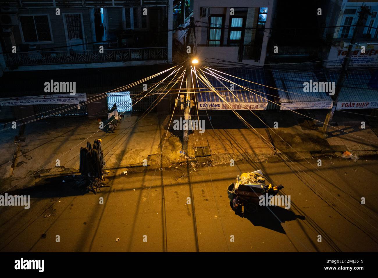 Stromleitungen erzeugen nachts wunderschöne Schatten - Müllmann - Vietnam Stockfoto