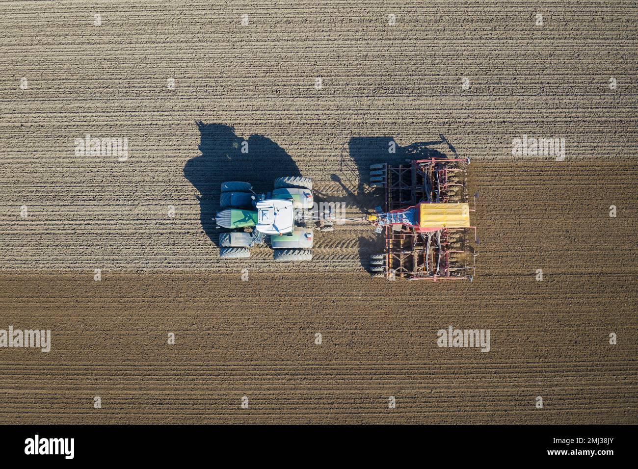 Draufsicht über Traktor mit pneumatischem Sämaschinen, landwirtschaftliche Maschine zum Aussaaten, Feldarbeiten im Frühjahr Stockfoto