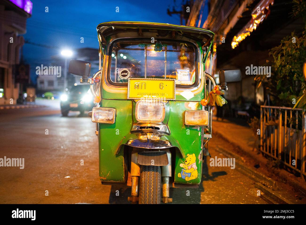 Ein grünes und gelbliches Tuk-Tuk bei Nacht in Thailand Stockfoto