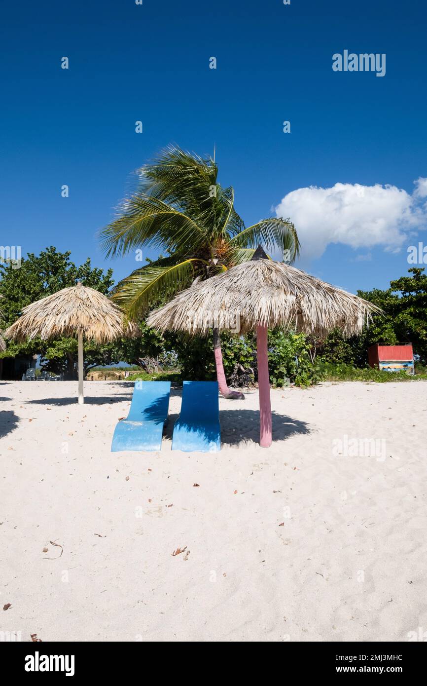 Am Strand am Playa Ancon in der Nähe von Trinidad, Kuba, befinden sich Liegestühle und Sonnenschirme aus Plastik Stockfoto