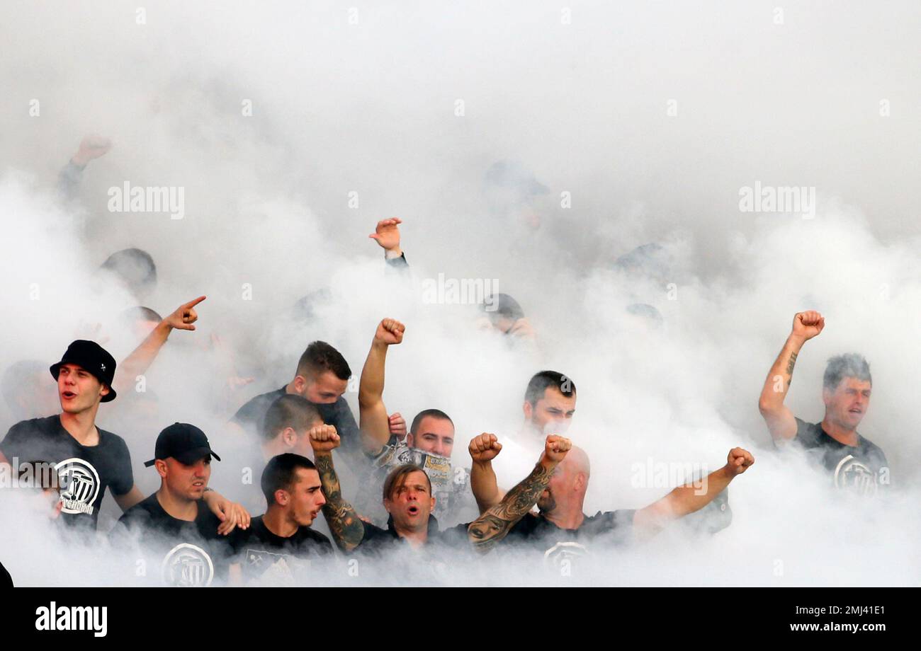 Partizan fans surrounded by smoke, support their team during a Serbian National soccer league derby match between Partizan and Red Star, in Belgrade, Serbia, Sunday, Sept. 22, 2019. (AP Photo/Darko Vojinovic) Stockfoto