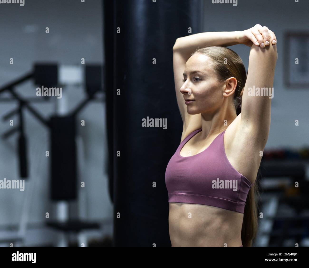 Ein Mädchen mit einem wunderschönen Sportkörper macht sich in der Boxhalle warm Stockfoto