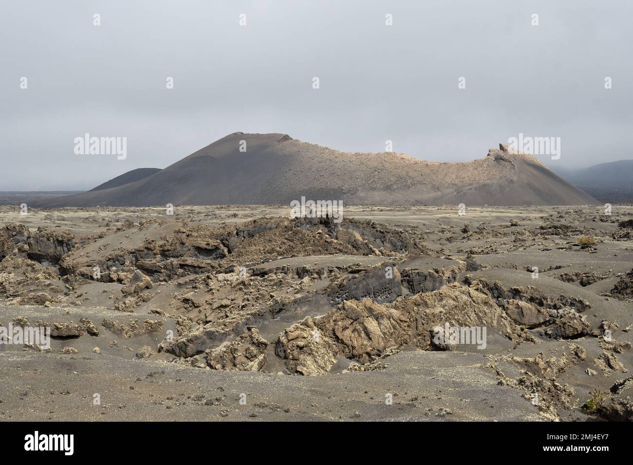 Ein alter Vulkankegel umgeben von Lava in Tinajo, Lanzarote Stockfoto