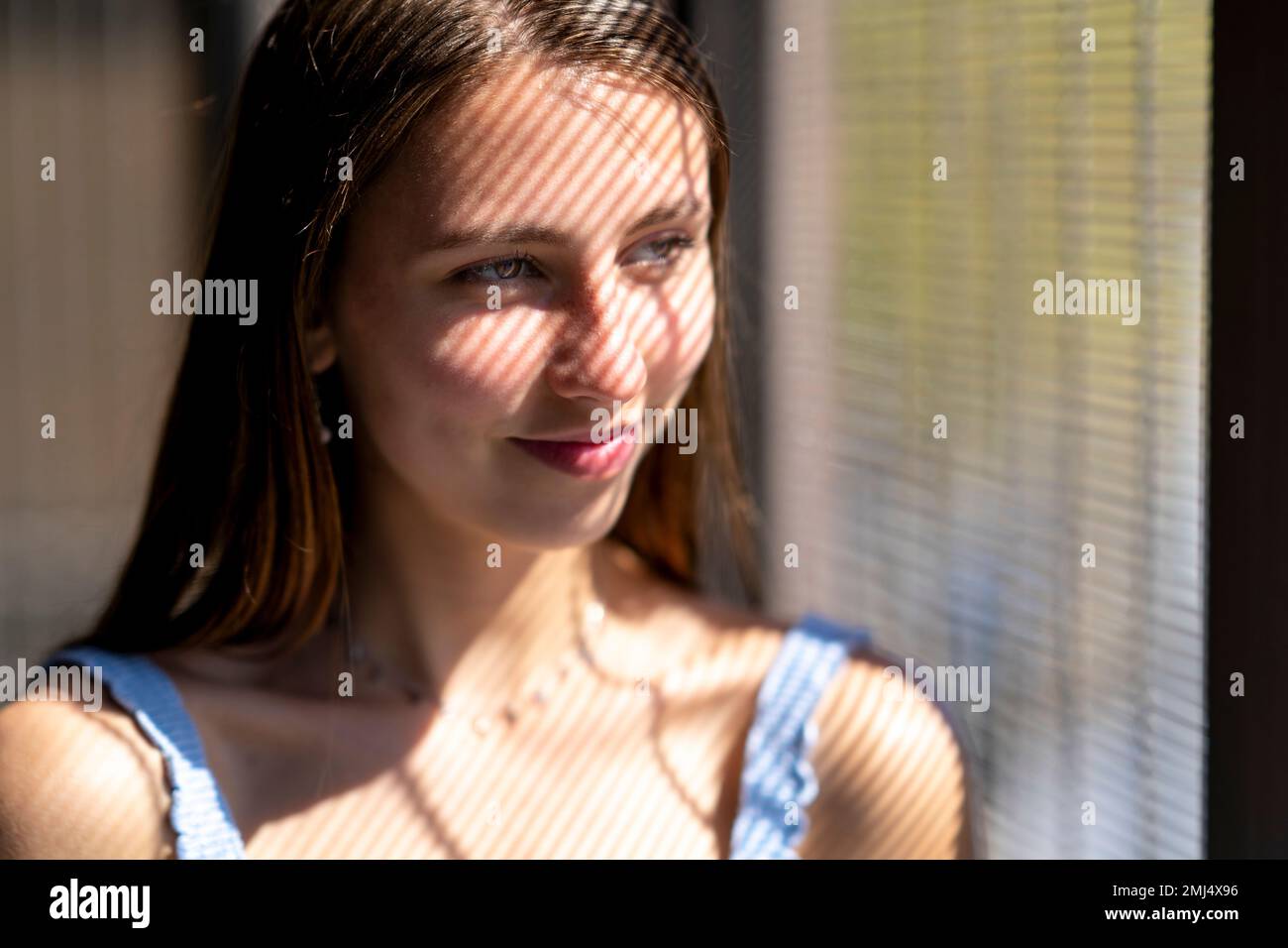 Nahaufnahme der schönen Teenage Girl, die in Striped Shadow lächelt Stockfoto