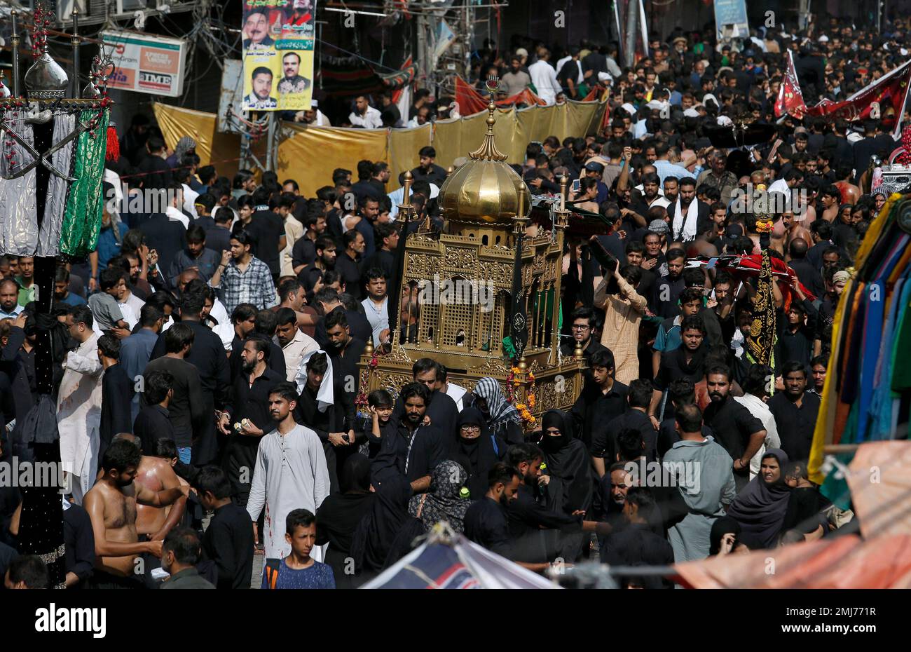 Shiite Muslims carry a replica of the shrine of Imam Hussein in Karbala ...