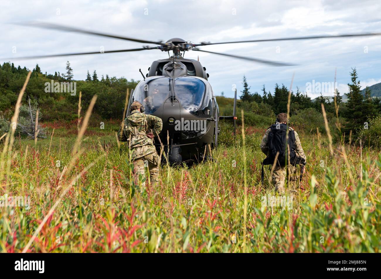 USA Air Force Tech. Sergeant Anthony Downs und Staff Sgt. Derek Bolton, Stabwetteroffiziere in Einheit 3, 1. Kampfwetterstaffel, kehren zu einem Alaska National Guard UH-72A Lakota Light Utility Helicopter zurück, während einer Untersuchung der Geronimo Drop Zone im Vorfeld der anstehenden Flugeinsätze auf der Joint Base Elmendorf-Richardson, Alaska, 25. August, 2022. Das 1. CWS bietet Vorausplanung der Atmosphäre und maßgeschneiderte Ausbeutungskapazitäten für Befehlshaber der Bodenstreitkräfte und Luftfahrzeuge. Stockfoto