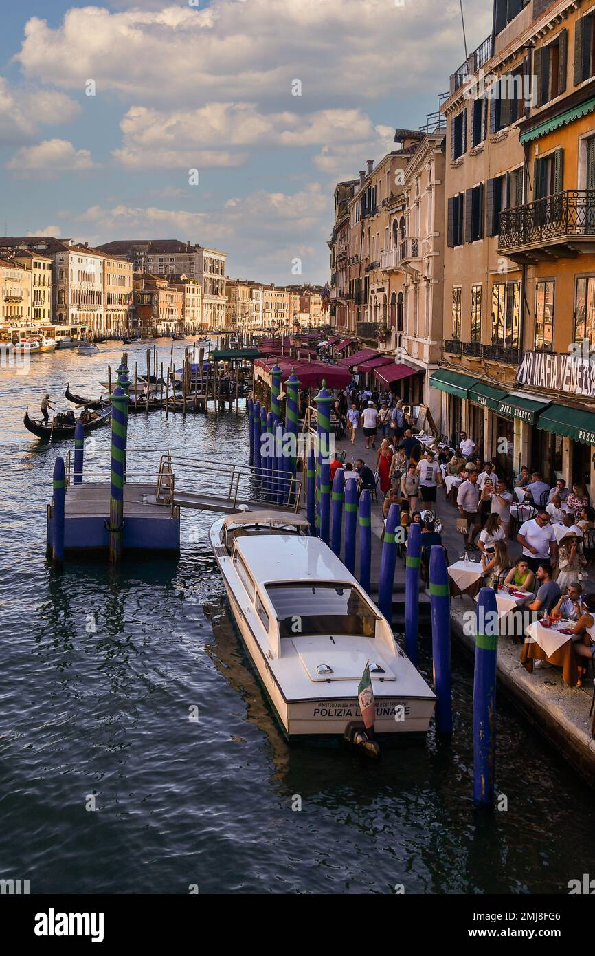 Erhöhte Aussicht auf den Canal Grande mit Straßenrestaurants voller Touristen zum Abendessen bei Sonnenuntergang im Sommer, Venedig, Venetien, Italien Stockfoto