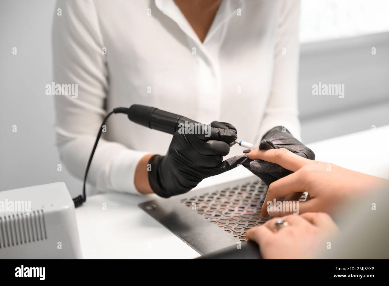 Professioneller Nagelkünstler, der mit einem Kunden im Schönheitssalon arbeitet, Nahaufnahme Stockfoto