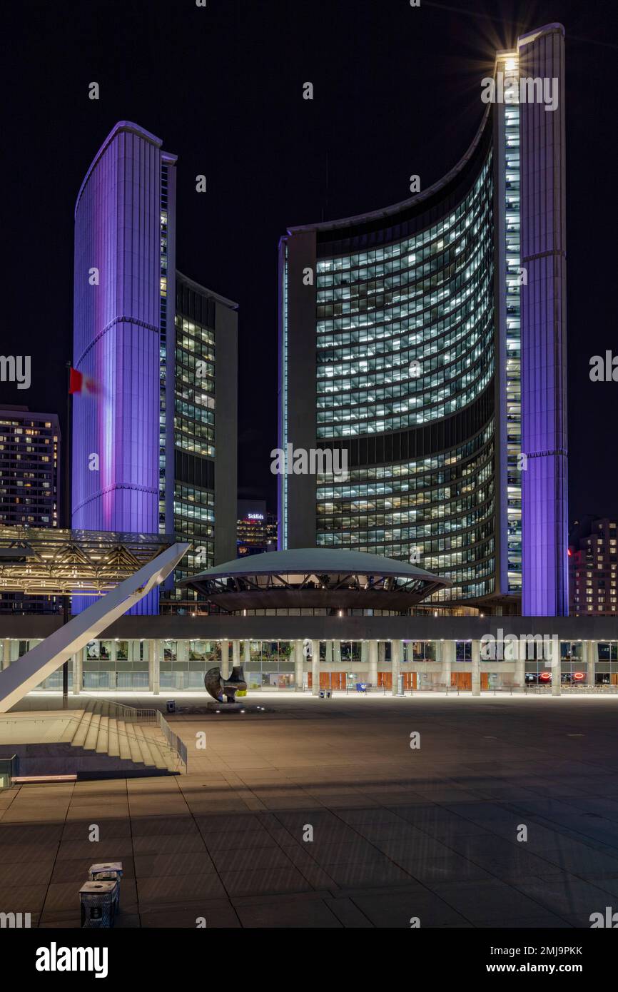 Die berühmten geschwungenen Bürotürme und die zentrale Untertasse leuchten bei dieser Nachtaufnahme des berühmten Rathauses von Toronto malerisch auf. Stockfoto