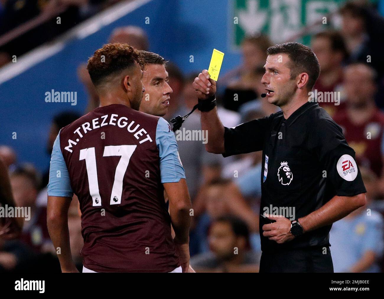 Referee Michael Oliver, right, shows a yellow card to Aston Villa's Trezeguet during the English Premier League soccer match between Aston Villa and Everton at Villa Park in Birmingham, England, Friday, Aug. 23, 2019. (AP Photo/Rui Vieira) Stockfoto
