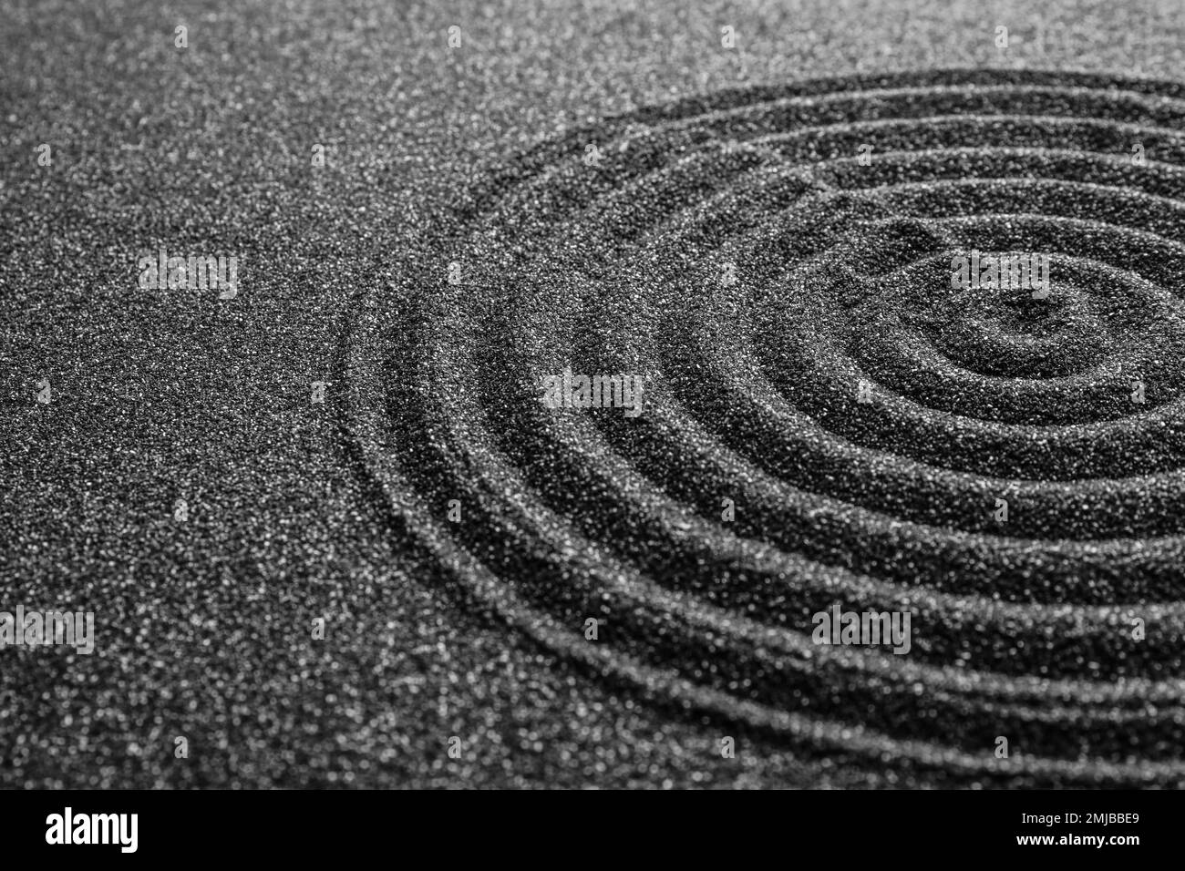 Schwarzer Sand mit wunderschönem Muster, Nahaufnahme. Zen-Konzept Stockfoto