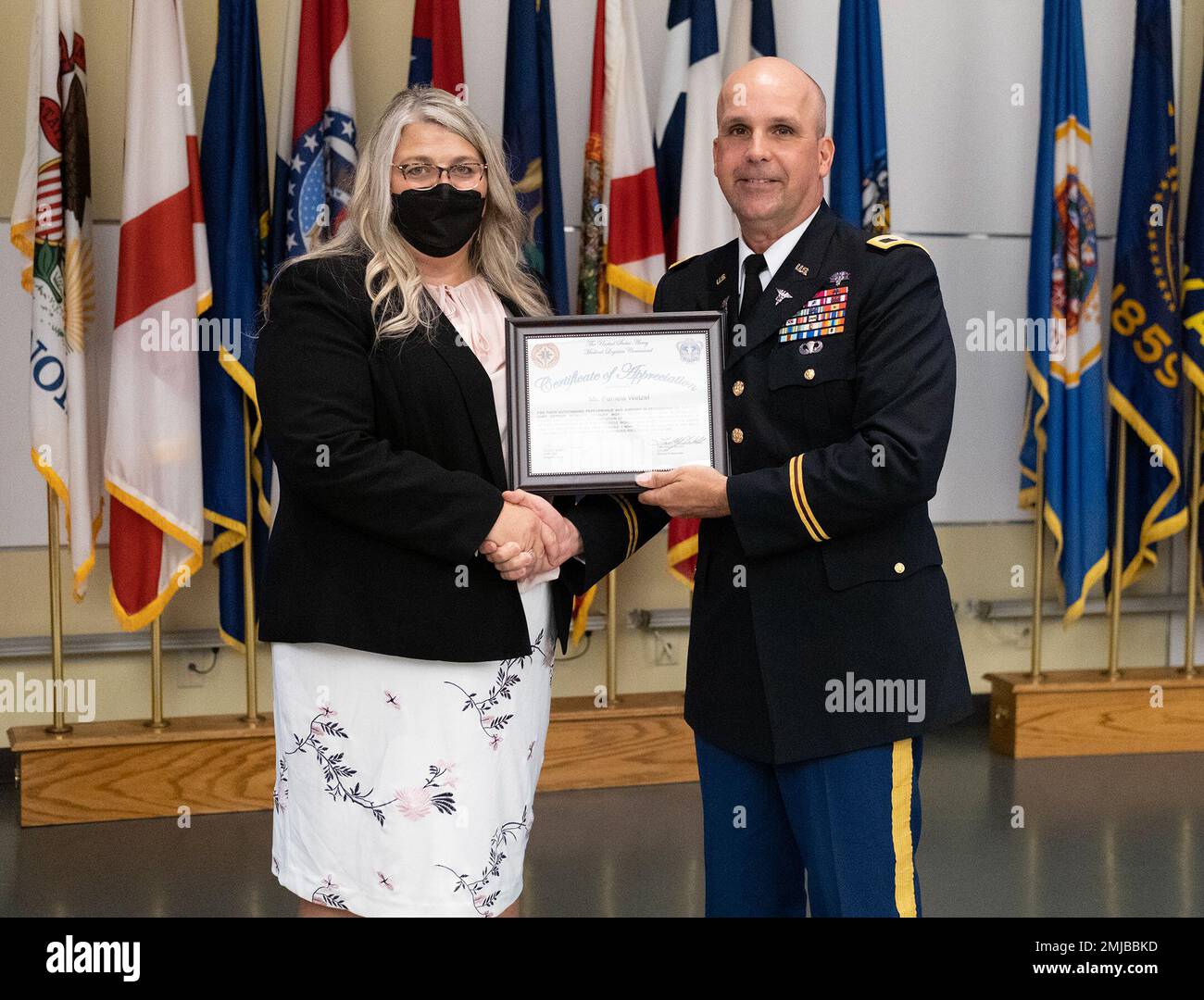 Colonel Timothy Walsh, stellvertretender Commander der USA Army Medical Logistics Command, stellt Pam Wetzel eine Anerkennung für ihre Unterstützung der AMLC-Veranstaltung zum Frauentag am 26. August in Fort Detrick, Maryland, vor. Stockfoto