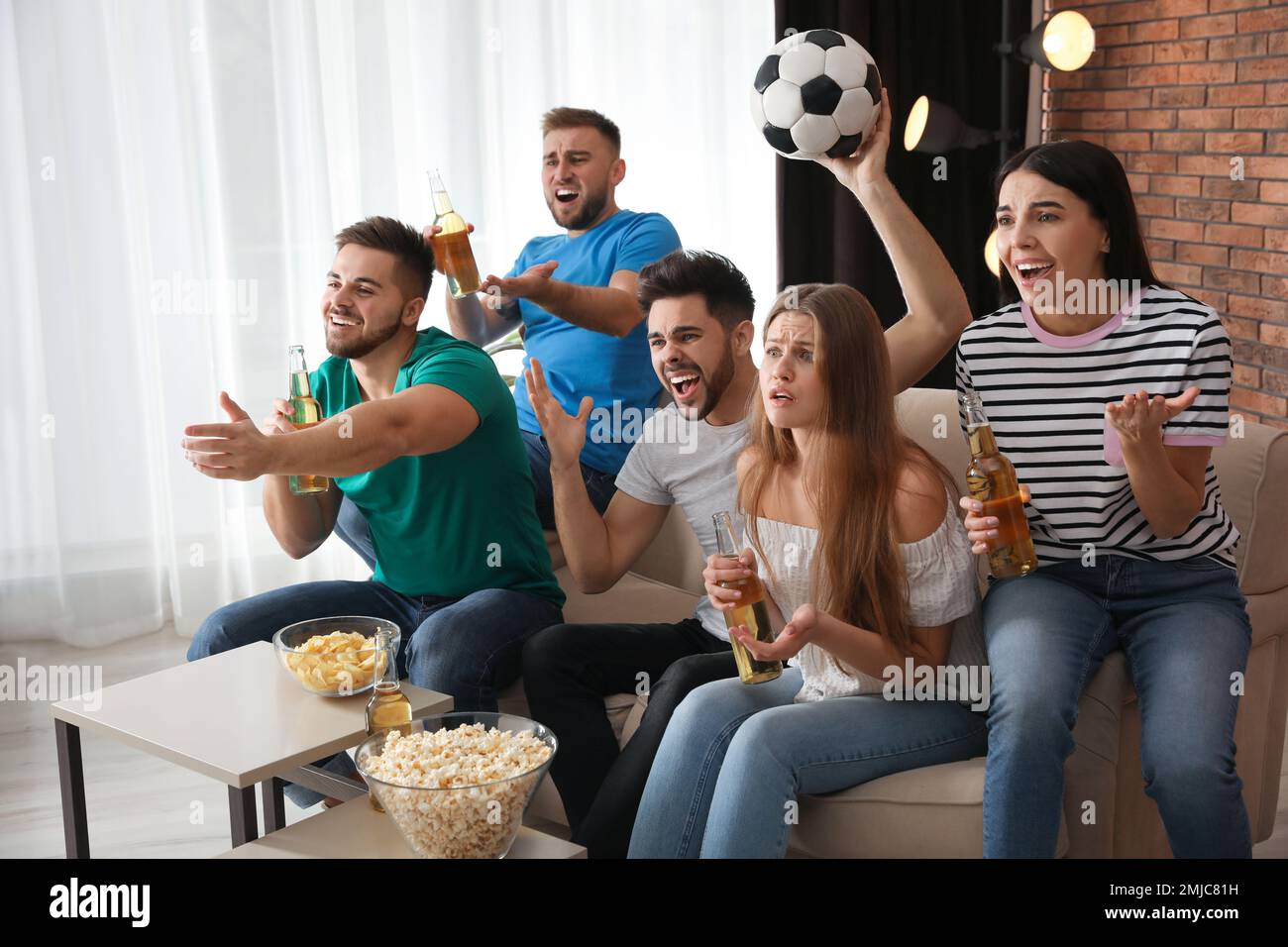 Eine Gruppe von Freunden, die zu Hause Fußball gucken Stockfotografie -  Alamy