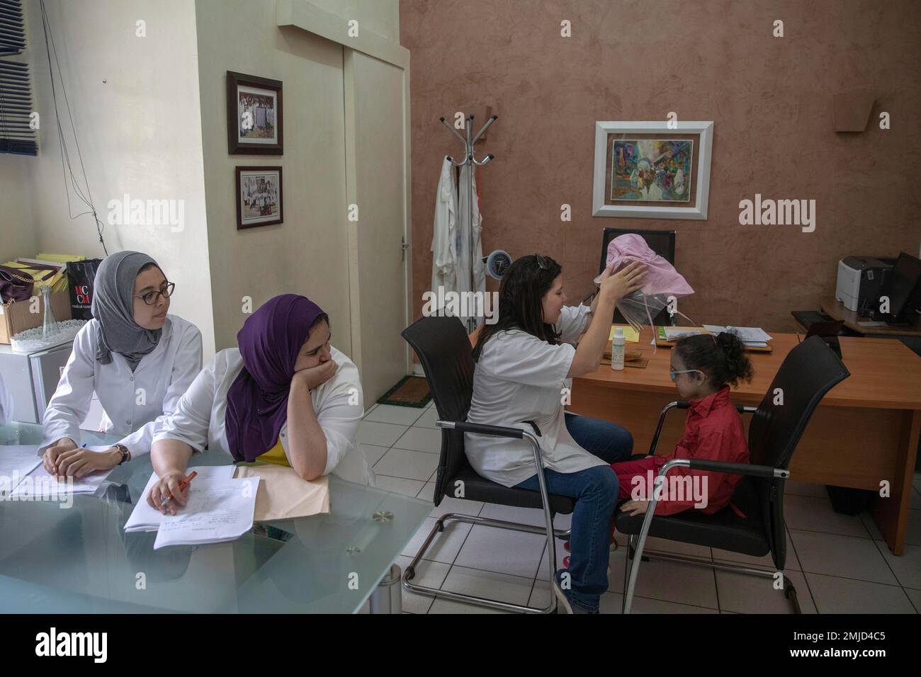 In this Wednesday, July 24, 2019 photo, a nurse takes off a protective mask as she performs skin