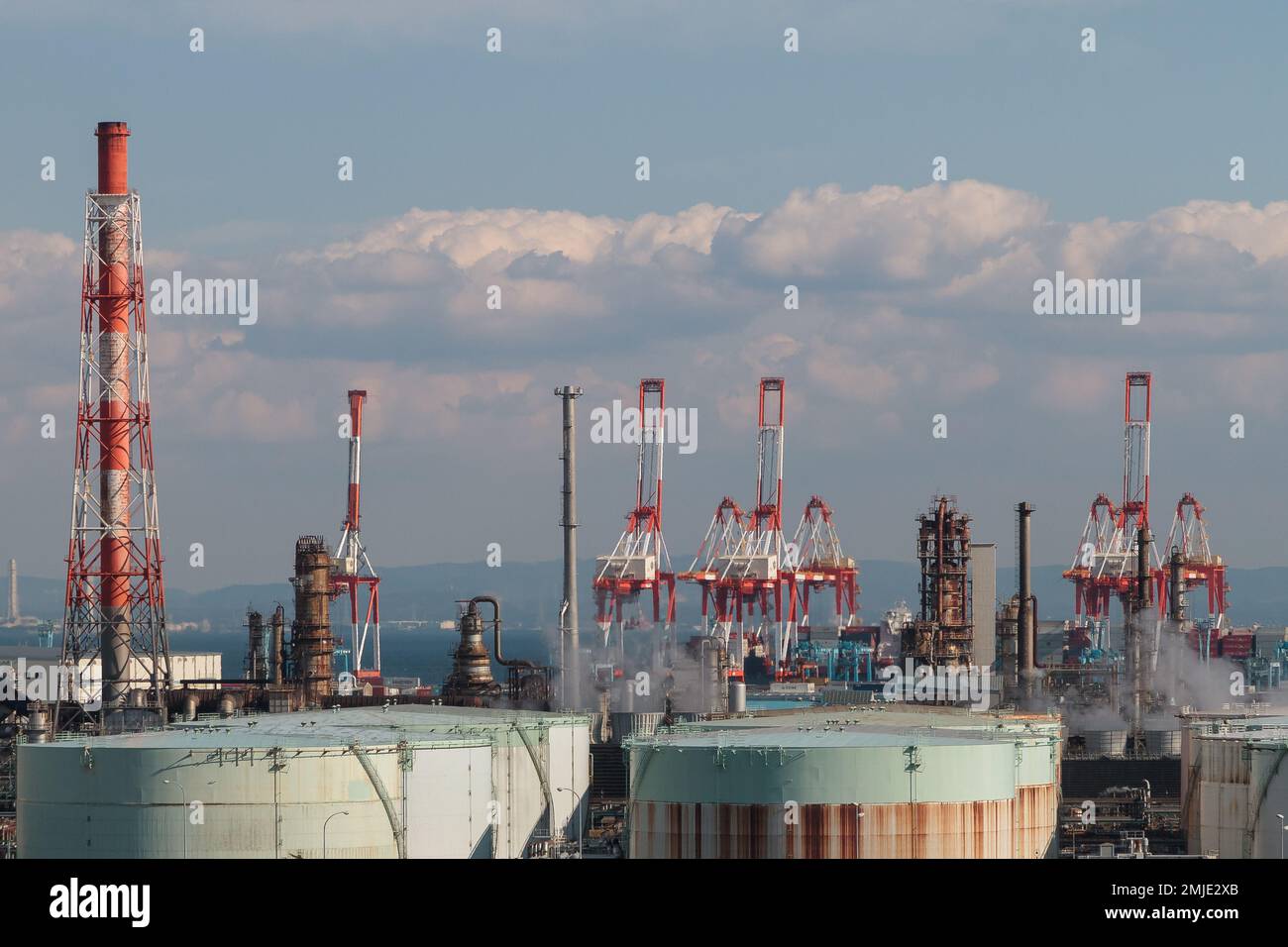 Kräne, Schornsteine und andere Industriearchitektur in der Nähe von Yokohama Bay, Kanagawa, Japan. Stockfoto