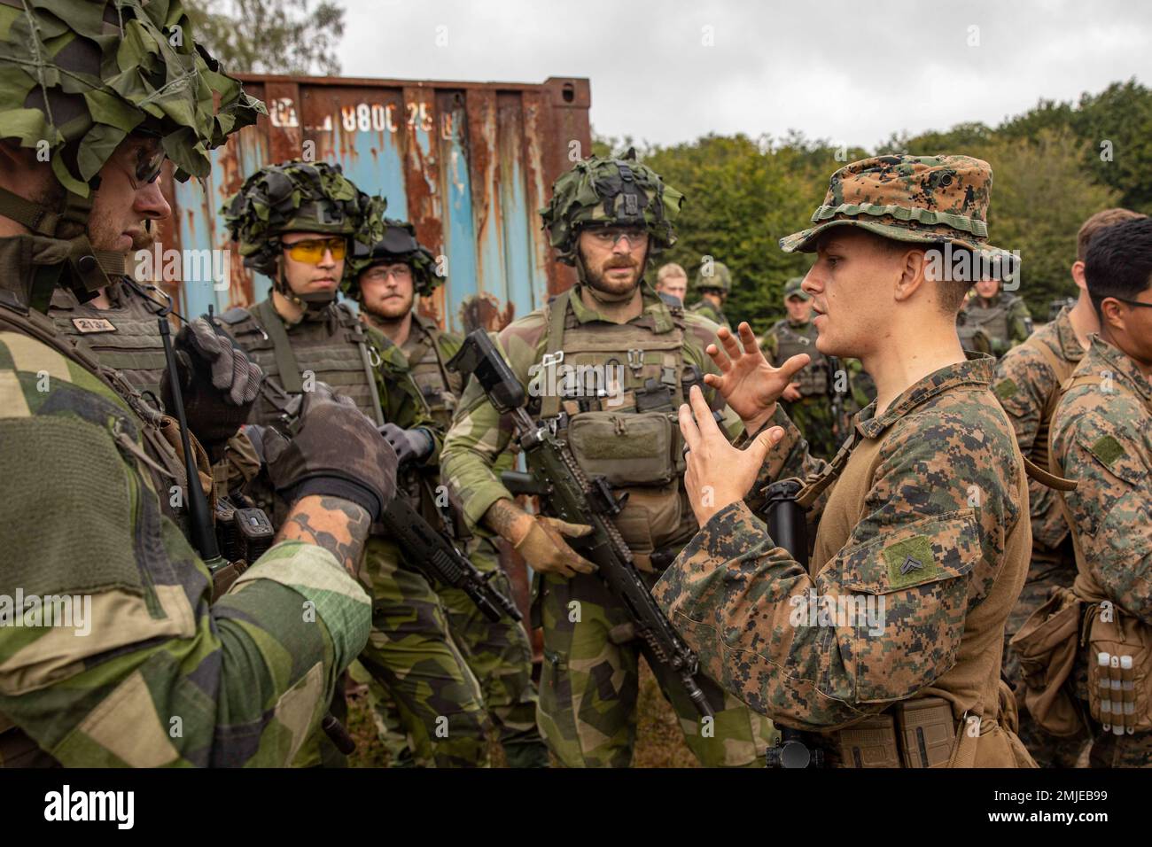 USA Ezra Harrison, Teamleiter der Echo Company, Bataillon Landing Team 2/6, 22. Marine Expeditionary Unit (MEU), spricht mit schwedischen Soldaten, die der Fifth Company, South Scania Regiment P7 bei Kristianstad, Schweden, zugewiesen wurden, 27. August 2022. Die Kearsarge Amphibious Ready Group und die 22. MEU, unter dem Kommando und der Kontrolle der Task Force 61/2, befinden sich auf einem geplanten Einsatz in den USA Marinestreitkräfte Europa Einsatzgebiet, angestellt von den USA Sechste Flotte, die die Interessen der USA, Verbündeten und Partner verteidigt. Stockfoto