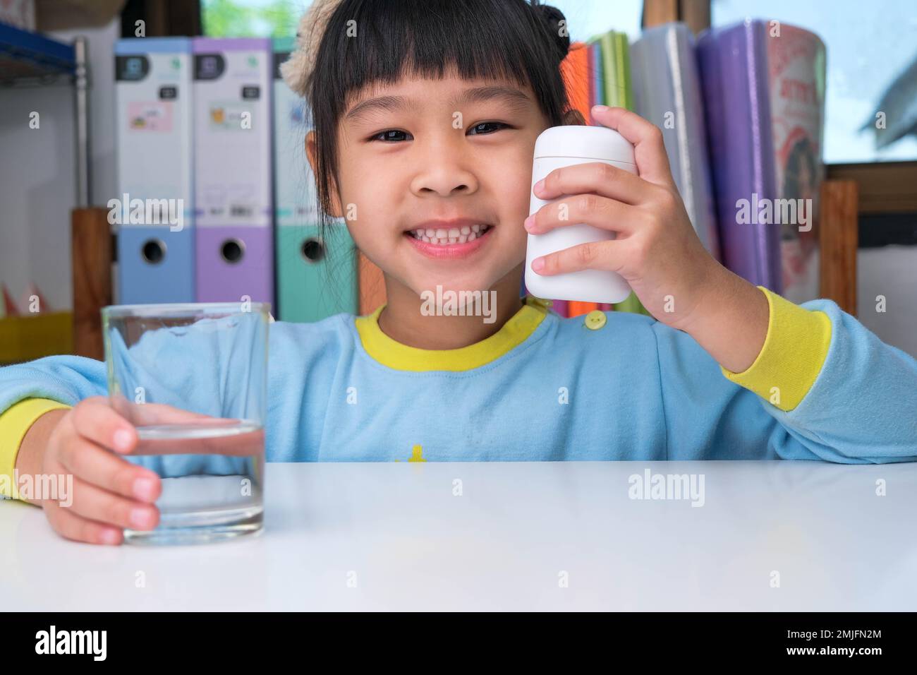 Süßes kleines Mädchen, das Alpha Omega 3 oder Vitamin Pille isst. Vitaminpräparate für Kinder zur Verbesserung der Immunität. Stockfoto