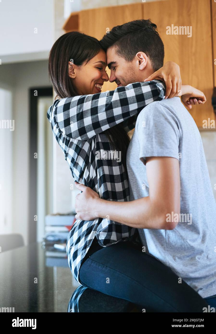 Sie können einfach nicht genug von einander bekommen. Ein glückliches junges Paar, das seinen Umzug in ein neues Zuhause feiert. Stockfoto