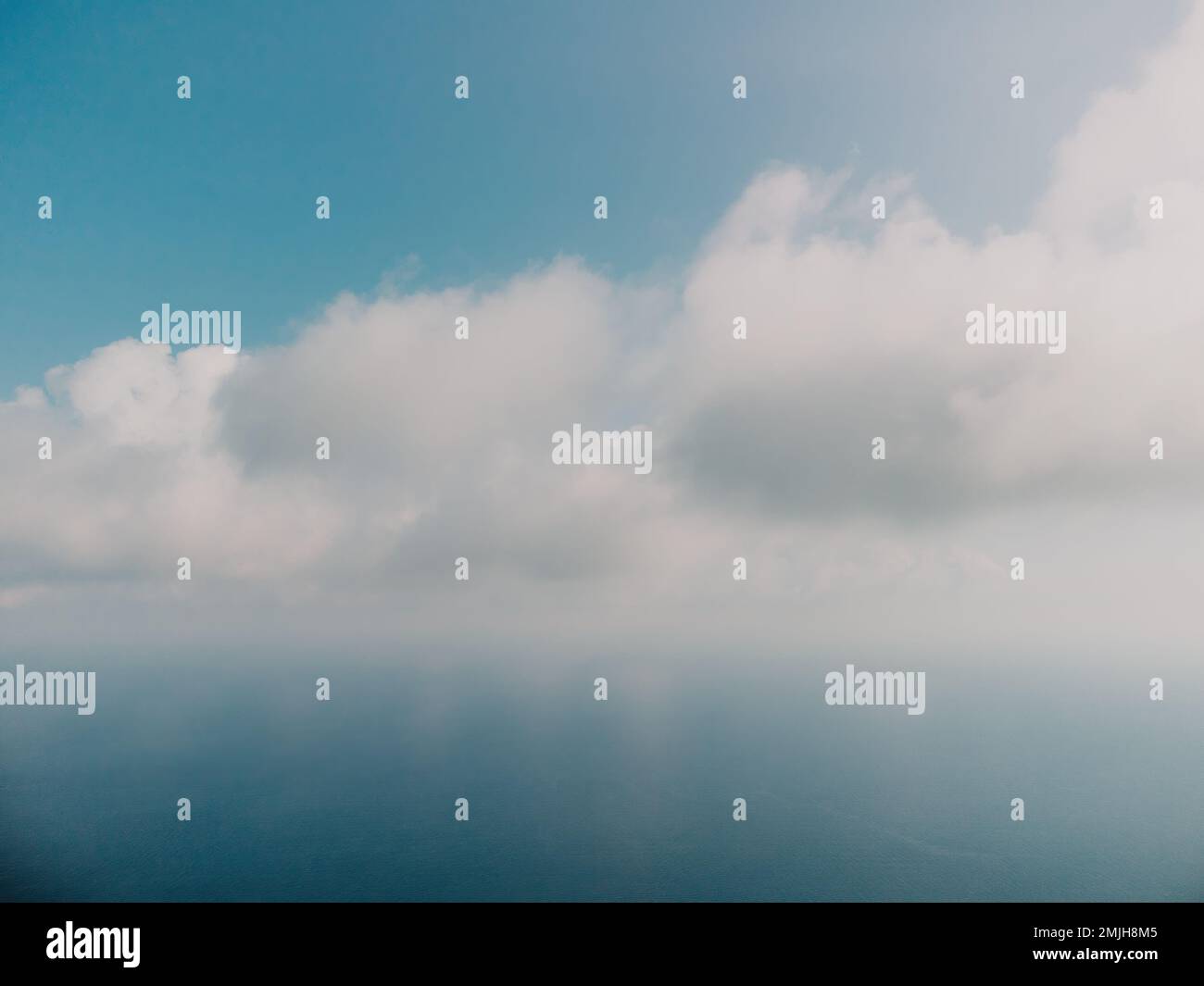 Blauer Himmel mit weißen Wolken über ruhigem Sommerpanorama des Meeres. Draufsicht der Drohne. Abstrakte Luft Natur Sommer Ozean Sonnenuntergang Meer und Himmel Hintergrund Stockfoto