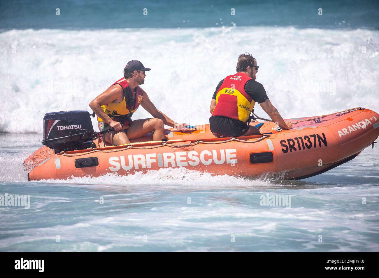 Freiwillige von Surf Rescue fahren ihr Zodiac-RIB-Schlauchboot vor Narrabeen Beach Sydney im Meer, zwei Männer Surf-Rettungsmannschaft im Boot, Australien Stockfoto