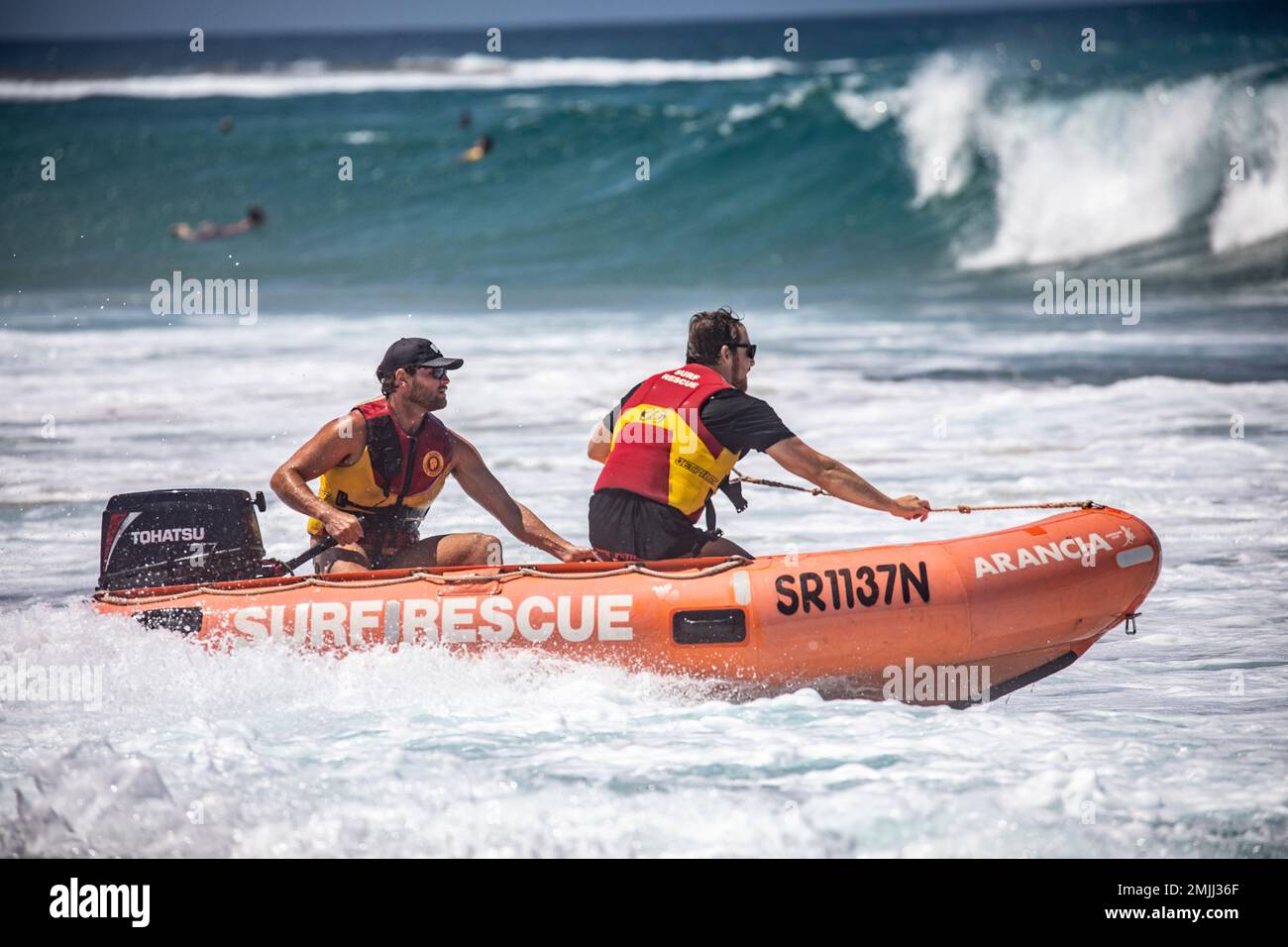 Freiwillige von Surf Rescue fahren ihr Zodiac-RIB-Schlauchboot vor Narrabeen Beach Sydney im Meer, zwei Männer Surf-Rettungsmannschaft im Boot, Australien Stockfoto