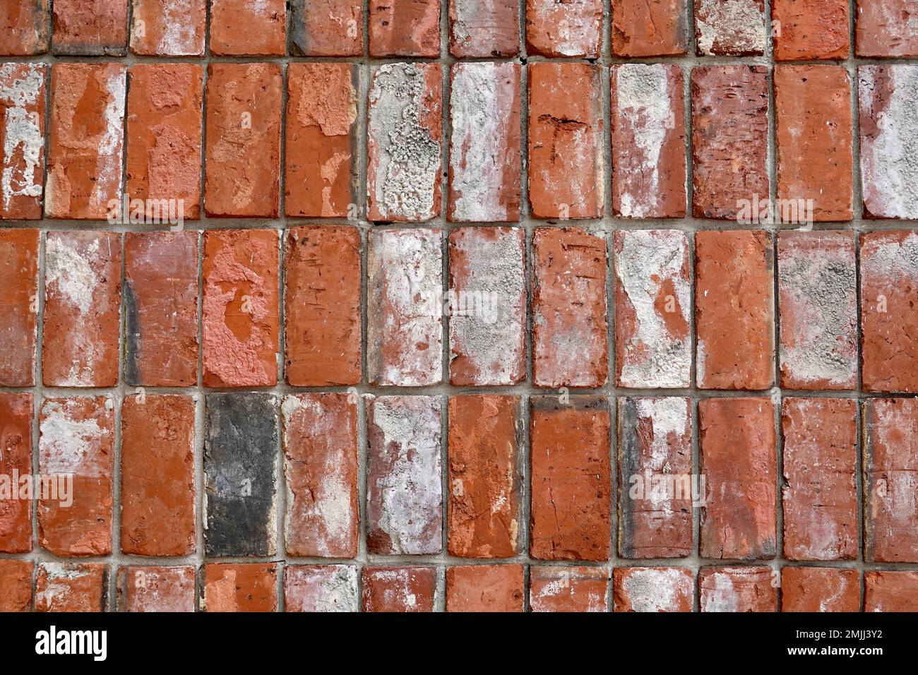Nahaufnahme einer verwitterten roten Backsteinmauer. Stockfoto