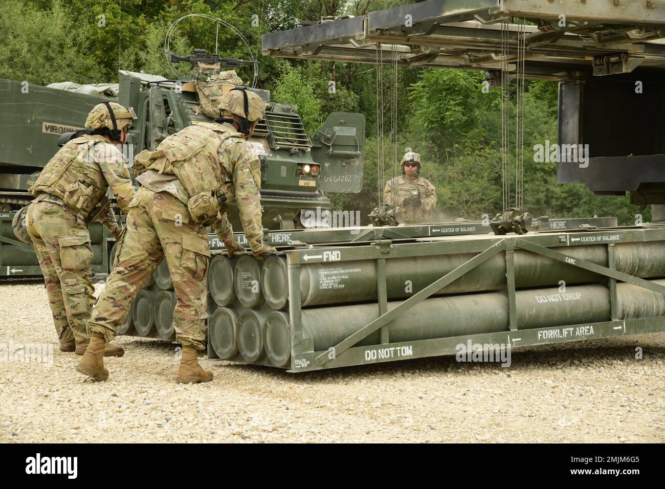 USA Soldaten, die der Arctic Battery, dem 1. Bataillon, der 6. Artillerie, der 41. Artillerie-Brigade zugeteilt wurden, verwenden das integrierte Windensystem, um Raketensysteme in das M270. Multiple Launch Rocket System (M270 MLRS) zu laden, um eine Live-Feuerdemonstration während des „Molly Pitcher Day“ am Trainingsgelände Grafenwoehr, 31. August 2022, vorzubereiten. Stockfoto