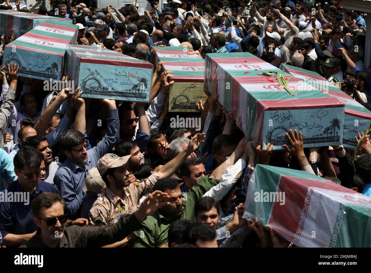 Mourners carry flag-draped caskets in a mass funeral procession for 150 soldiers killed during the war with Iraq in the 1980s, as well as two others killed in Syria in 2016, whose remains were recently recovered in the battlefields, in Tehran, Iran, Thursday, June 27, 2019. (AP Photo/Vahid Salemi) Stockfoto