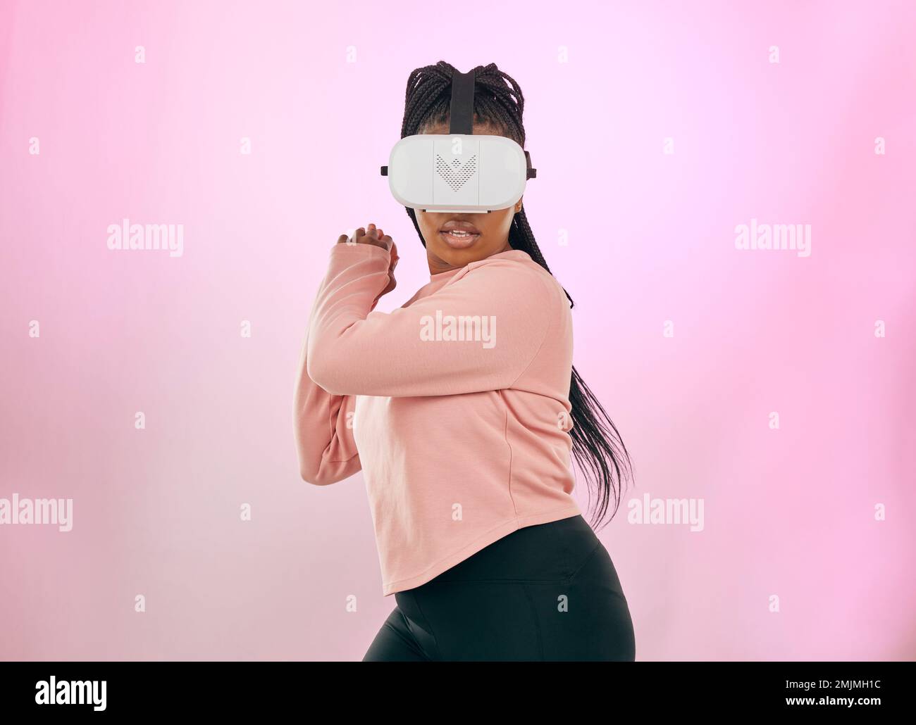Schwarze Frau, VR und Gamer im Metaverse für futuristisches Gaming oder Aktivitäten vor einem pinkfarbenen Studiohintergrund. Afroamerikanische Frau in 3D virtuell Stockfoto