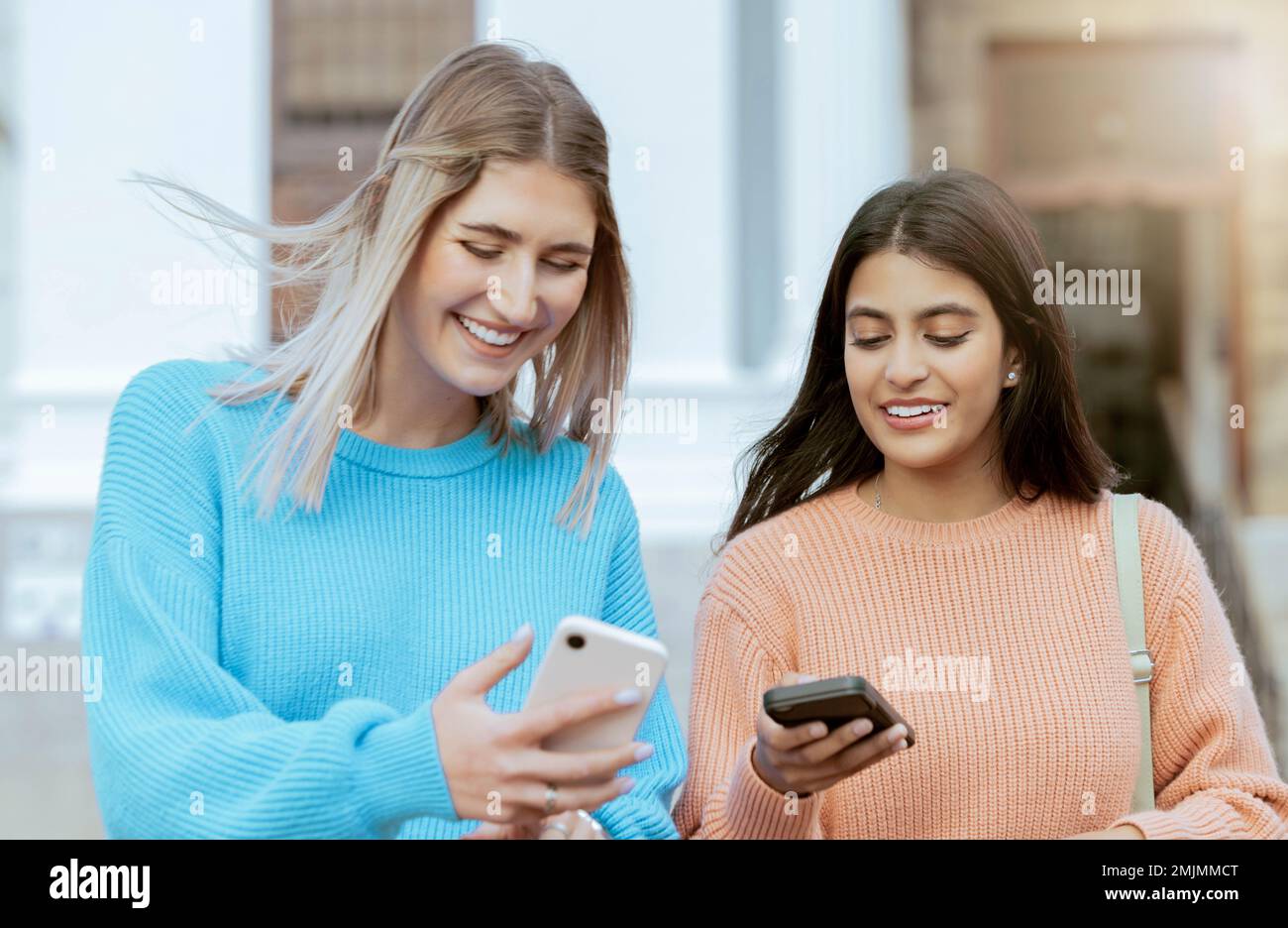 Freunde, Frauen mit Smartphone, soziale Medien und Technologie mit Schülern auf dem Campus, online und im Freien. Verbindung, Meme oder Posten mit Freude Stockfoto