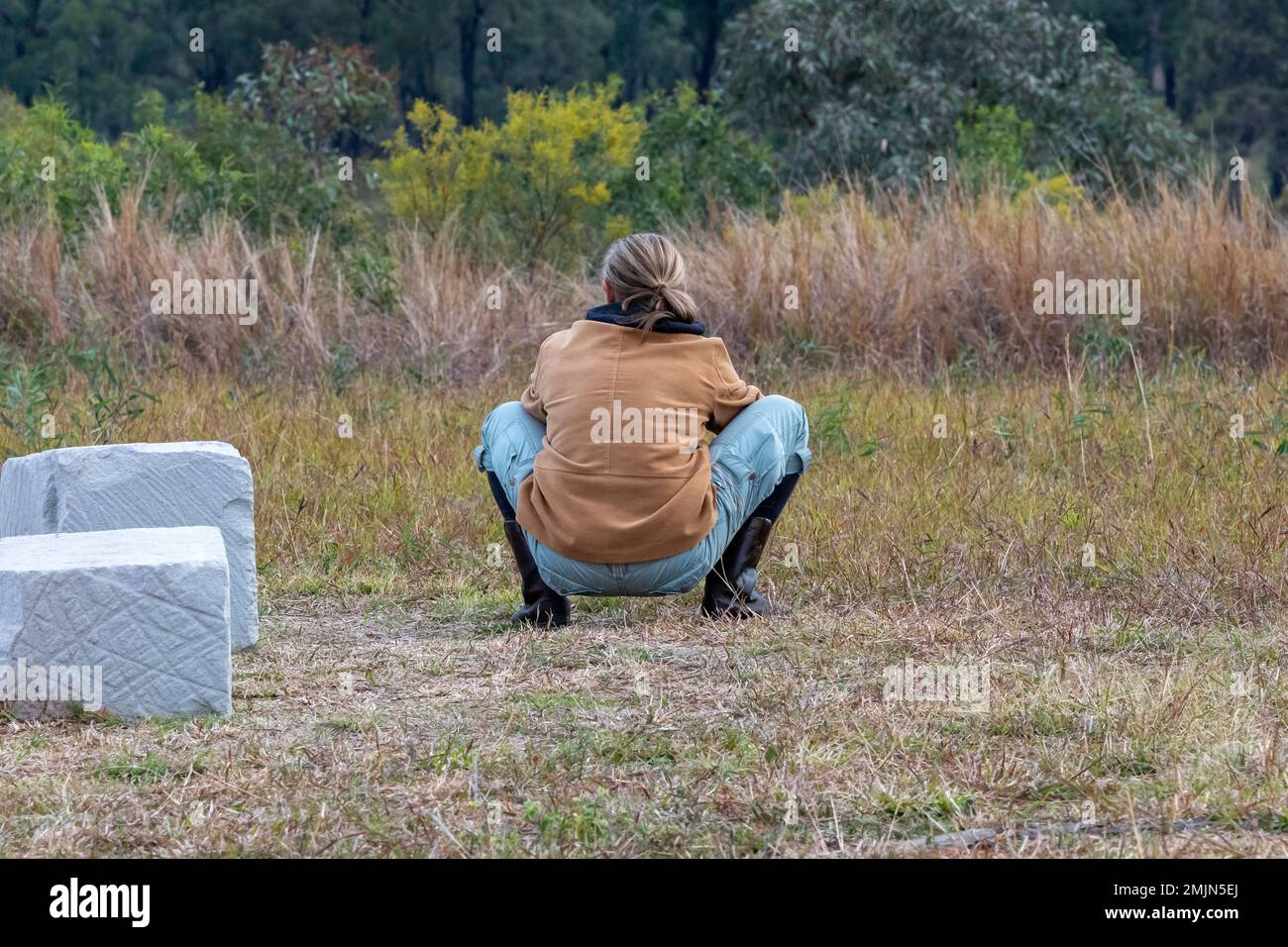 Person in einer Squat-Sitzposition mit Blick auf den Carnarvon National Park, Queensland, Australien Stockfoto