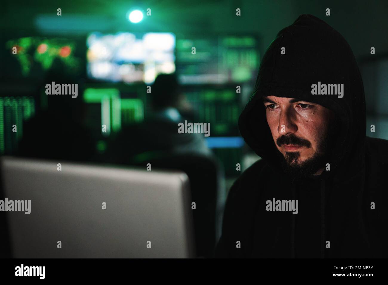 Nahaufnahme des Porträts eines Hackers, der auf den Bildschirm eines Laptops blickt und den Code eingibt, um die Sicherheit der Firewall im Internet zu verletzen. Hochwertiges Foto Stockfoto