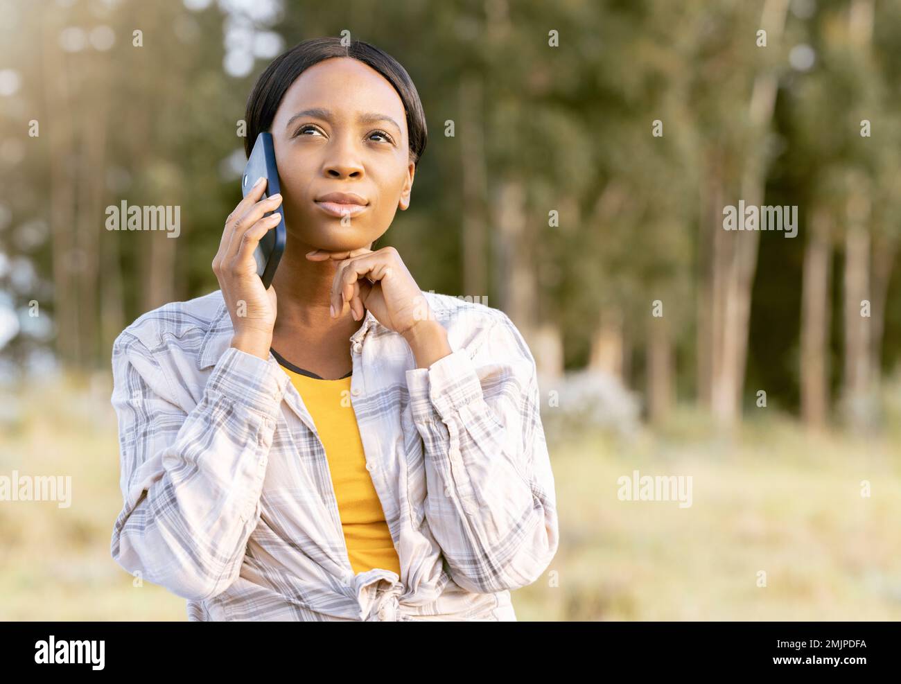 Schwarze Frau, Telefon und Denken in der Natur für Kommunikation, Reisen oder Mobilfunk-5G-Dienste im Freien. Afroamerikanische Frau, die sich Gedanken macht Stockfoto