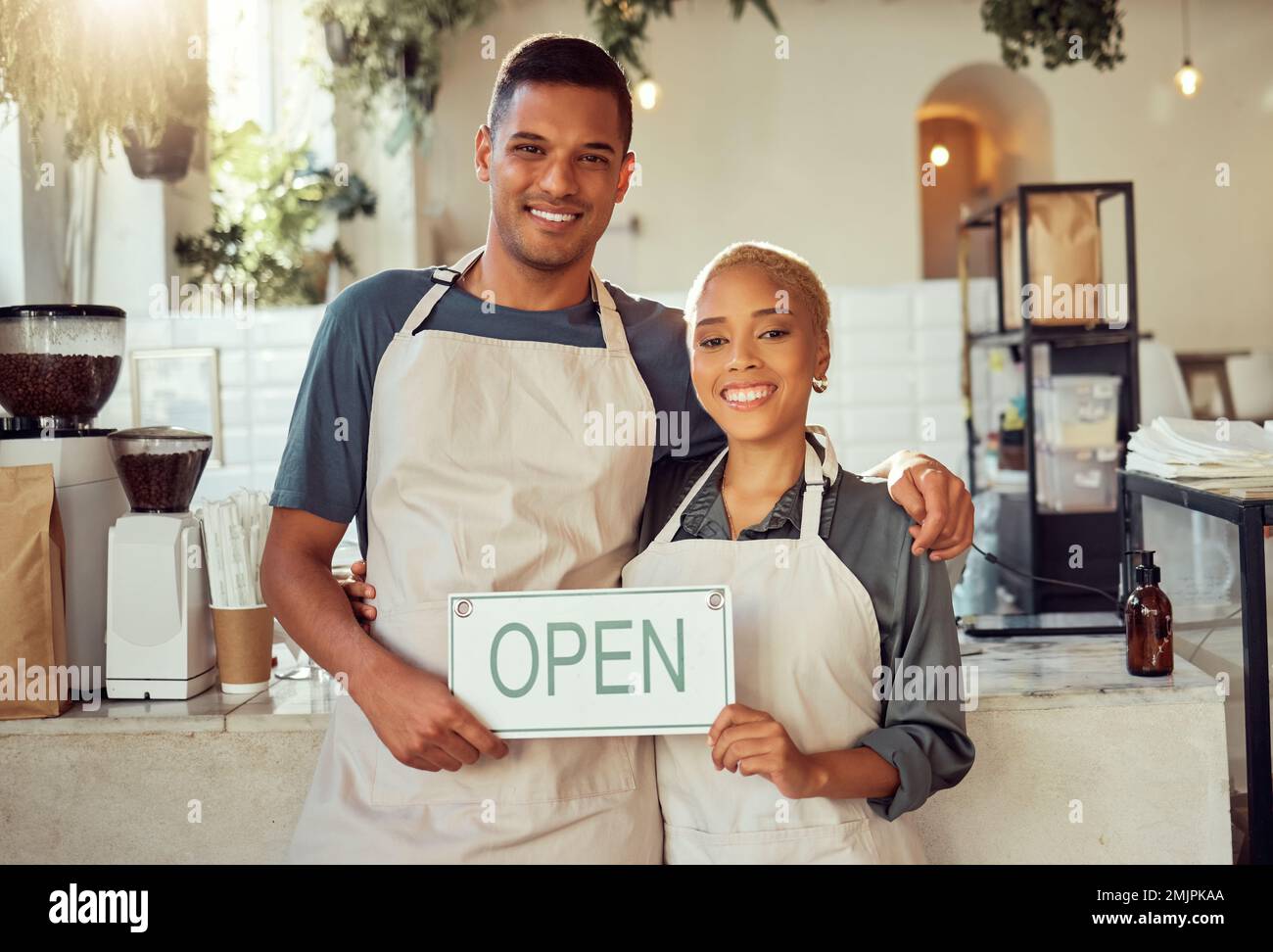 Café-Bar, Porträt und offenes Schild von kleinen Geschäftsinhabern in einem Café zur gemeinsamen Unterstützung. Team, Zusammenarbeit und Freunde, die beim Start lächeln Stockfoto