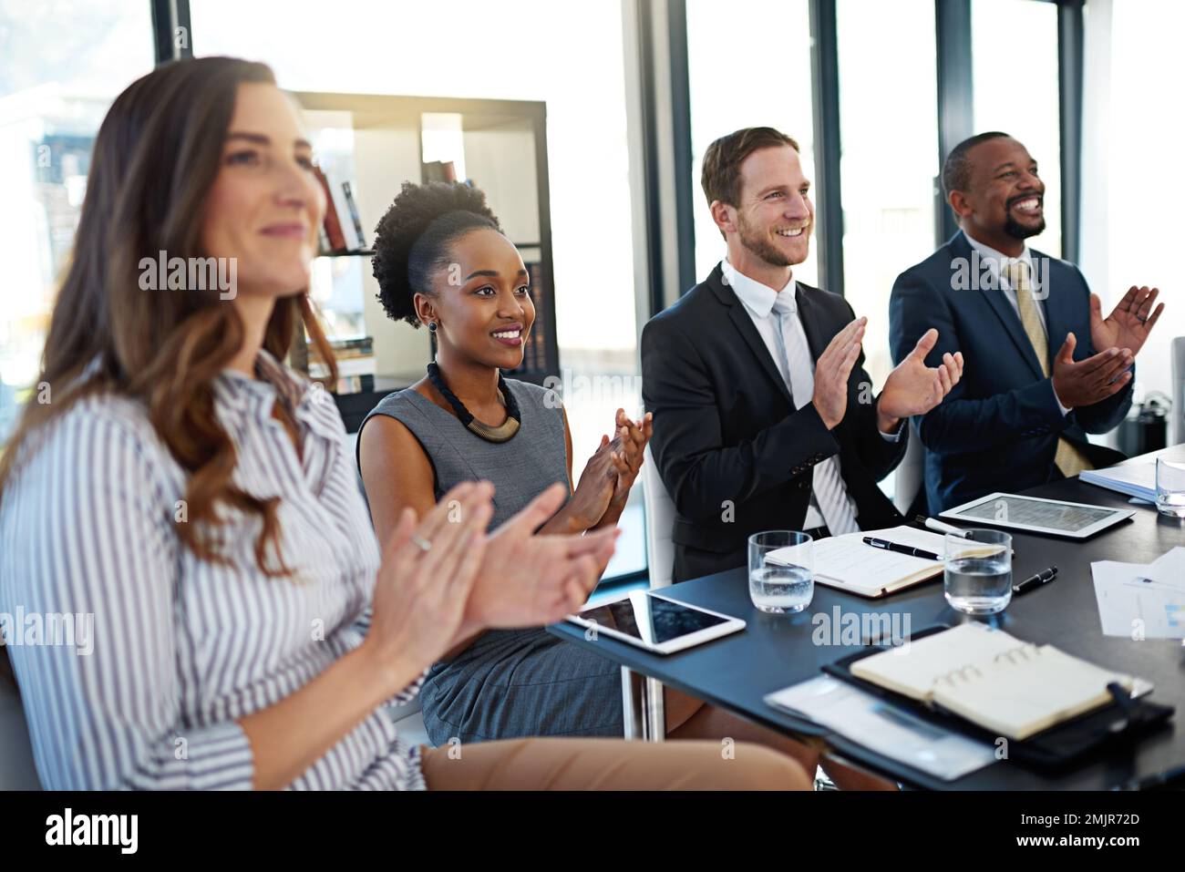 Respekt zu zollen, wo es angebracht ist. Eine Gruppe von Geschäftsleuten applaudiert, während sie im Sitzungssaal sitzt. Stockfoto