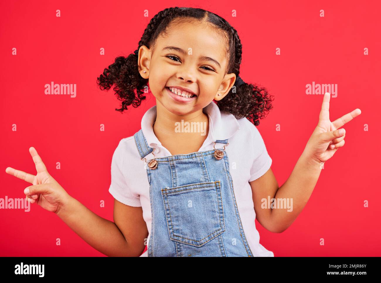 „Happy, Peace“-Schild und Porträt eines Lächelns auf rotem Hintergrund mit trendigen, stilvollen und niedlichen Sommeroutfits. Kinder Mode, Freiheit und Gesicht des Kindes Stockfoto