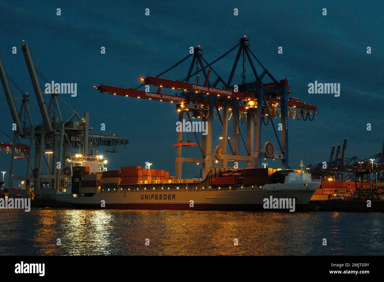 Containerschiff im hamburger Hafen bei Nacht. Stockfoto