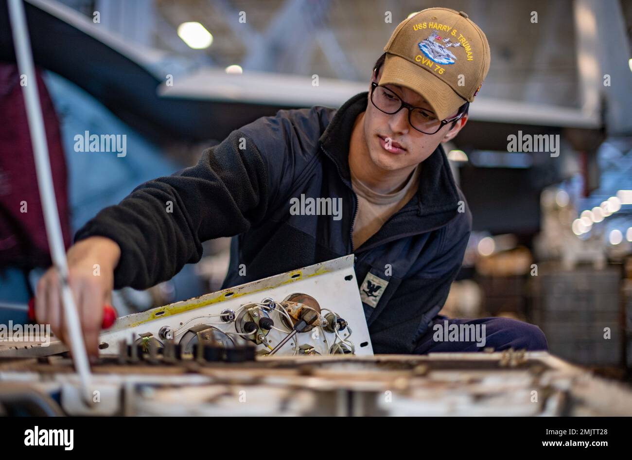 220901-N-XR893-1111 ATLANTIK (SEP. 1, 2022) Aviation Support Equipment Technician 3. Klasse Adam Titterall, aus Phillipsburg, New Jersey, entfernt die Schutzschalter-Verkleidung eines Speckers im Hangarbereich der USS Harry S. Truman (CVN 75), 1. September 2022. Die Harry S. Truman Carrier Strike Group befindet sich im geplanten Einsatzgebiet der US Naval Forces Europe und wird von der Sechsten Flotte der USA eingesetzt, um die Interessen der USA, der Alliierten und der Partner zu verteidigen. Stockfoto