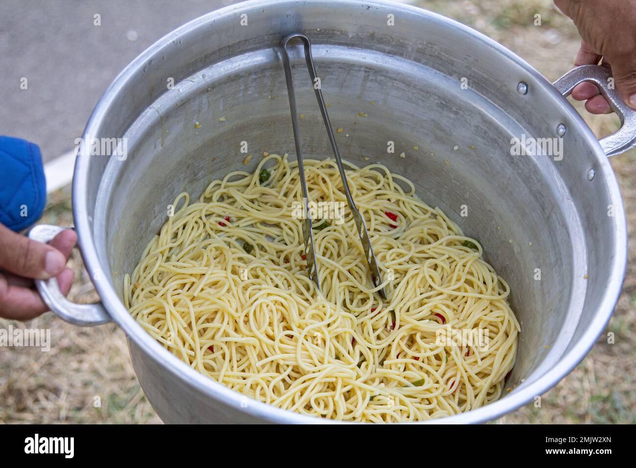 Eine Pfanne enthält Pasta in einer cremigen weißen Sauce mit Fischstücken, die wahrscheinlich in Butter sautiert und mit Kräutern und Gewürzen gewürzt sind. Die Pasta kann eine sein Stockfoto