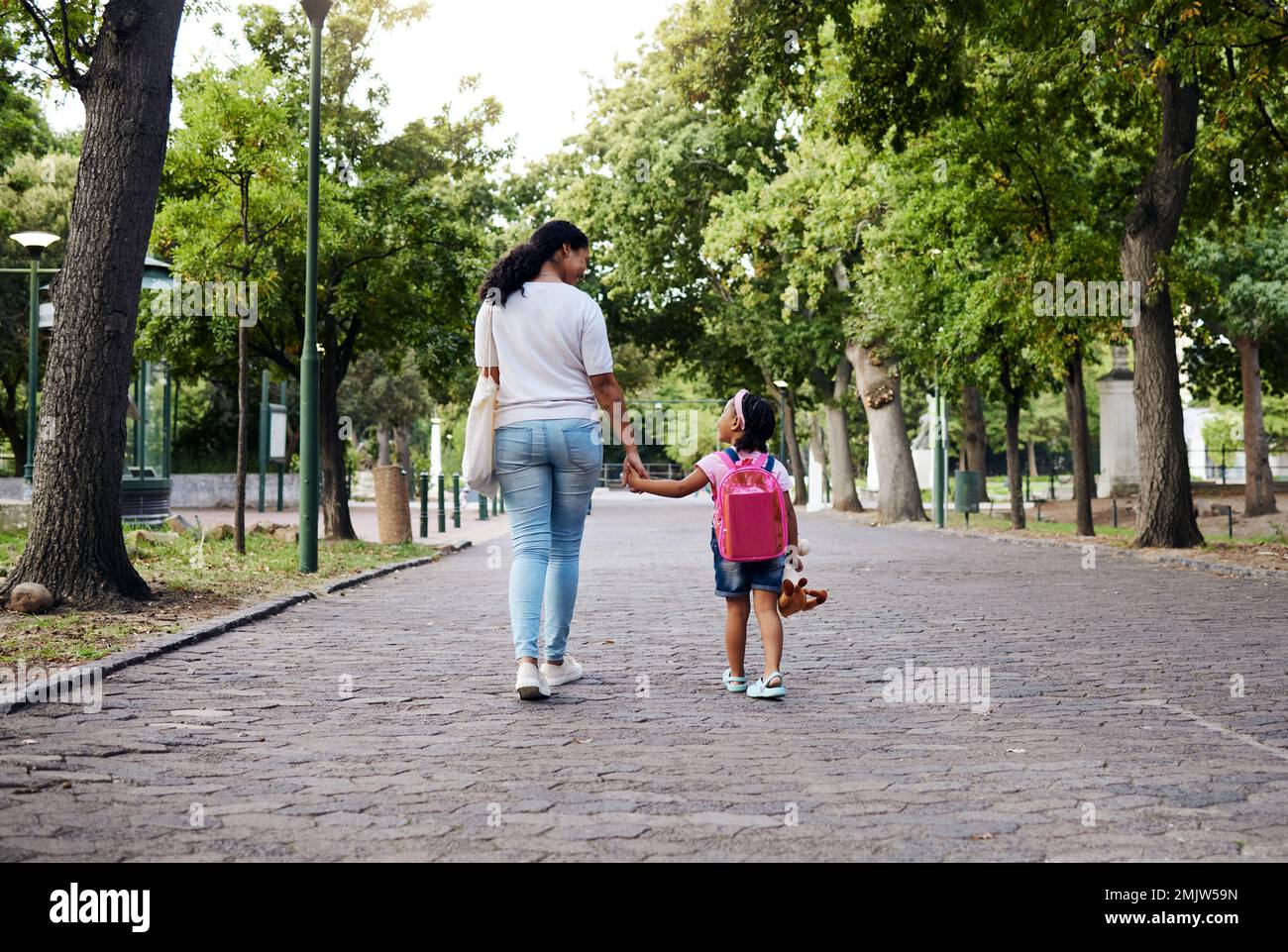 Gehen, Park und Mutter halten Händchen mit dem Mädchen auf dem Weg zurück zur Schule, lernen und Unterricht am ersten Tag. Liebe, schwarze Familie und mom Stockfoto