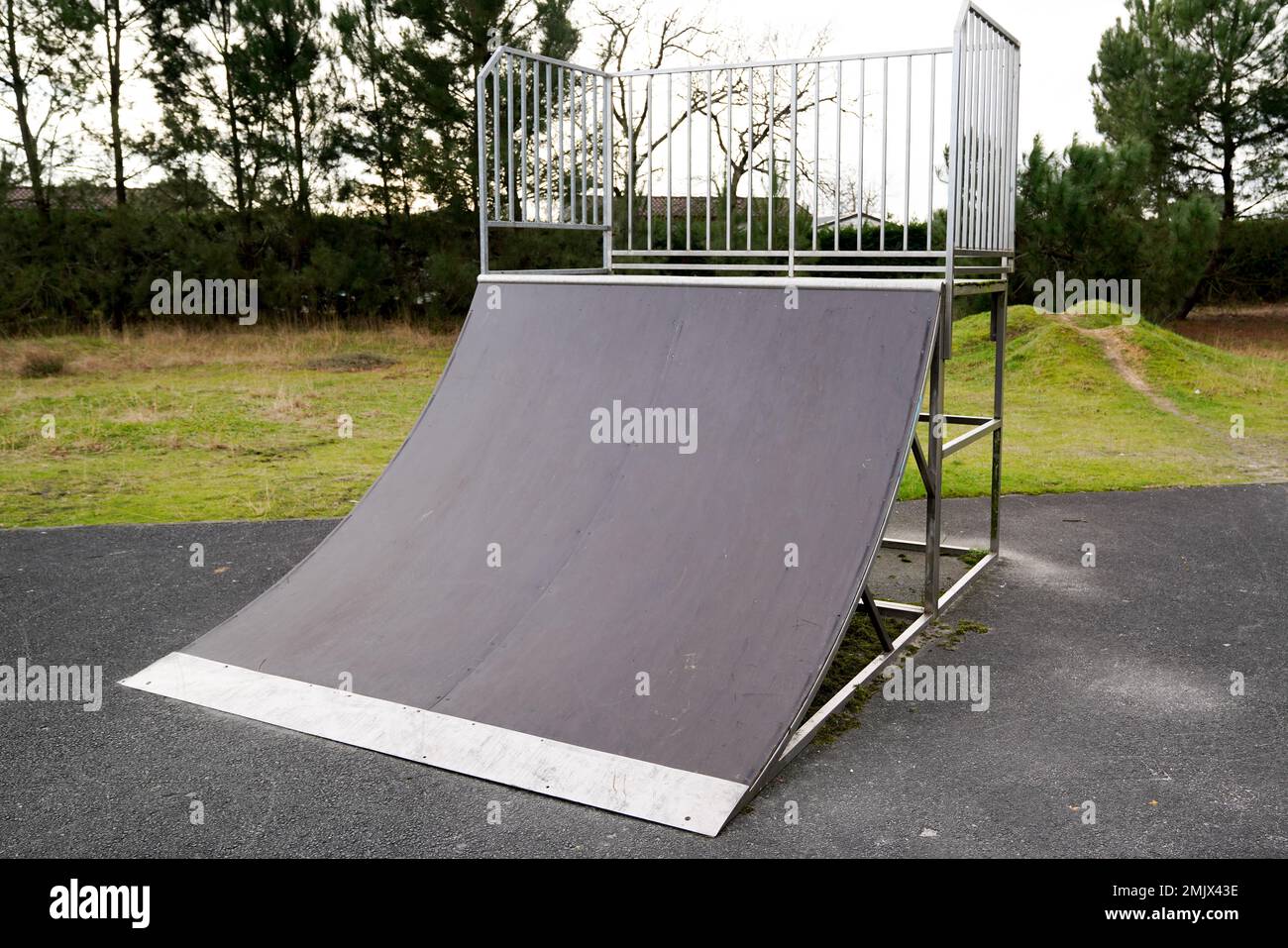 Spielplatz mit Viertelpfeifenrampe für Skateboarden und Abenteuersport im öffentlichen Park Stockfoto Spielplatz mit Viertelpfeifenrampe für Skateboarden und Abenteuersport im öffentlichen Park Stockfoto