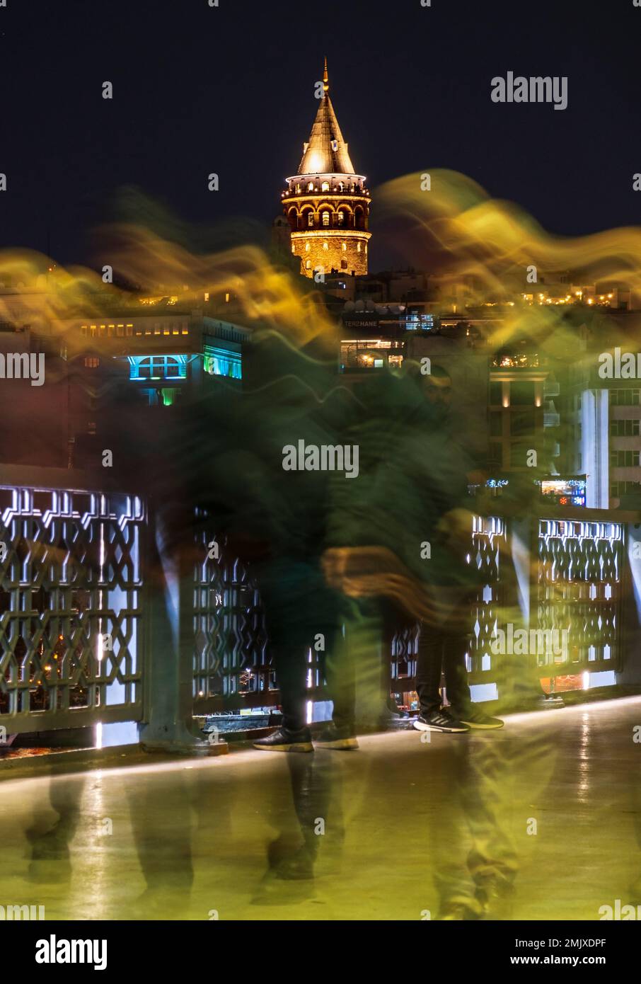 Istanbul, Türkei, 01.19.2023: Menschen, die nachts auf der Brücke spazieren gehen und im Hintergrund den Galata-Turm. Langzeitbelichtung Istanbul Nachtleben. Istanbul Stockfoto
