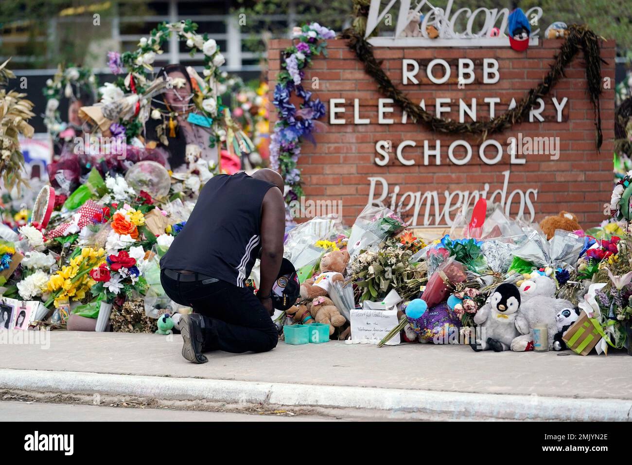 FILE - Reggie Daniels pays his respects a memorial at Robb Elementary School on June 9, 2022, in Uvalde, Texas, created to honor the victims killed in the recent school shooting. As mass shootings are again drawing public attention, states across the U.S. seem to be deepening their political divide on gun policies. A series of recent mass shootings in California come after a third straight year in which U.S. states recorded more than 600 mass shootings involving at least four deaths or injuries. (AP Photo/Eric Gay, File) Stockfoto